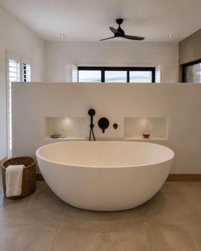a large white tub in a bathroom with a ceiling fan at Farmstead at ECS winery in Lake Marina