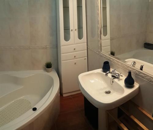 a bathroom with a tub and a sink and a bath tub at West House Peniche Consolação Apartment in Peniche