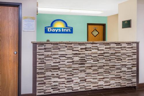 a lobby with a day inn sign on a brick wall at Days Inn by Wyndham Charleston in Charleston