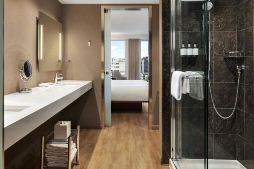 a bathroom with two sinks and a shower at AC Hotel by Marriott Madison Downtown in Madison