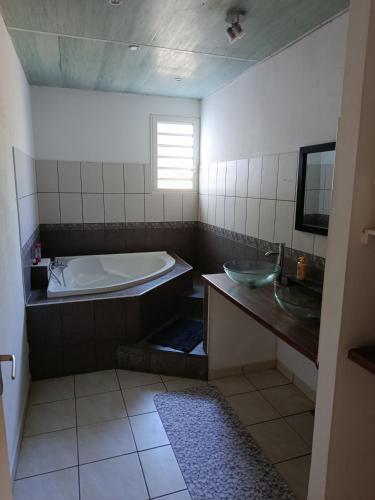 a bathroom with a bath tub and a sink at LaKaz Pascale T2 climatisé pour 4 adultes 1 enfant in Ravine des Cabris