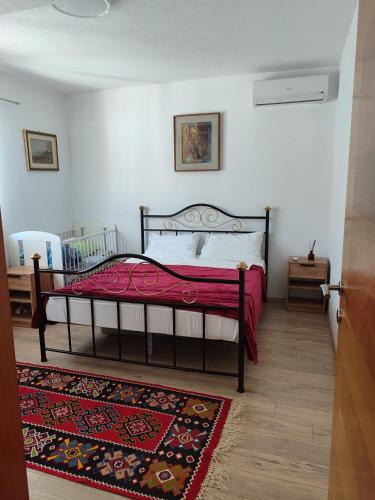 a bedroom with a bed with a red blanket at Pansion Ajlin in Blagaj