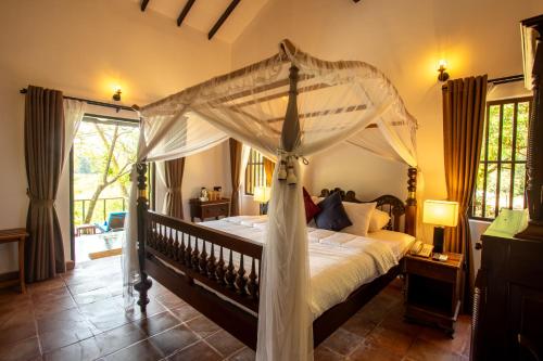a bedroom with a bed with a canopy at Serenity Wellness in Kuruwita