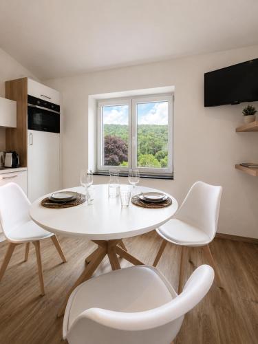 a white dining room with a white table and chairs at Station 33 in Spa