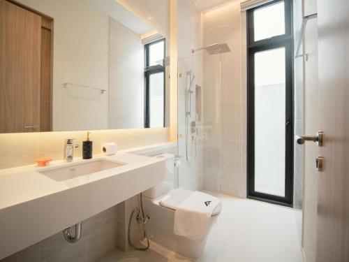 a white bathroom with a sink and a toilet at Villa Kauri 3BR Pool Villa at Aileen Naithon in Ban Sakhu