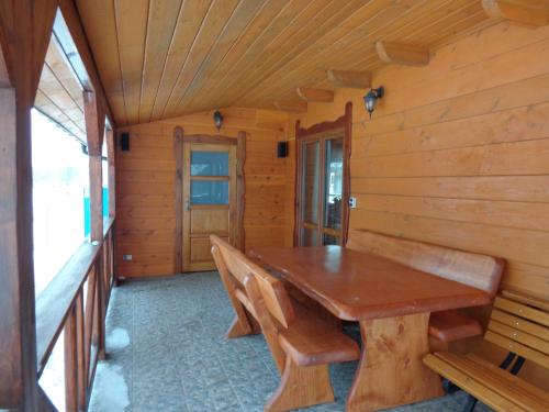 une salle à manger avec une table et des bancs en bois dans l'établissement U Witalisa, à Narewka