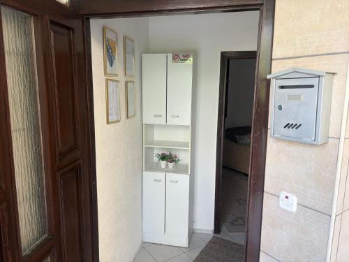 a door leading into a room with a refrigerator at Lav Apartments in Bihać