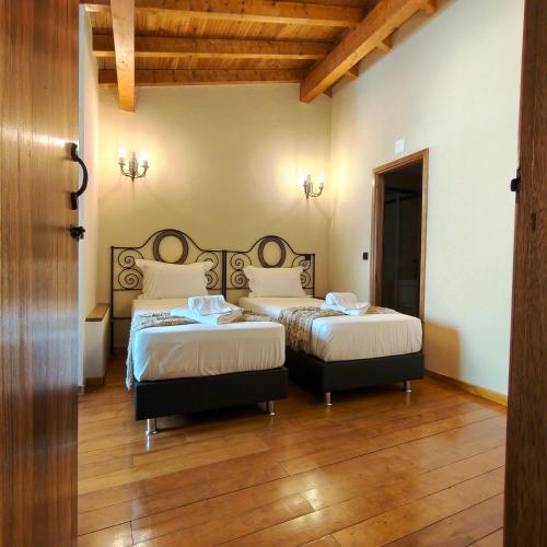 a bedroom with two beds and a wooden floor at Casa Fornos de Amor in Fornos de Algodres