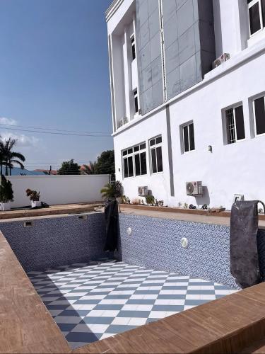 a patio with a checkered floor in front of a building at Chrisvirgy Hotels in Kubwa