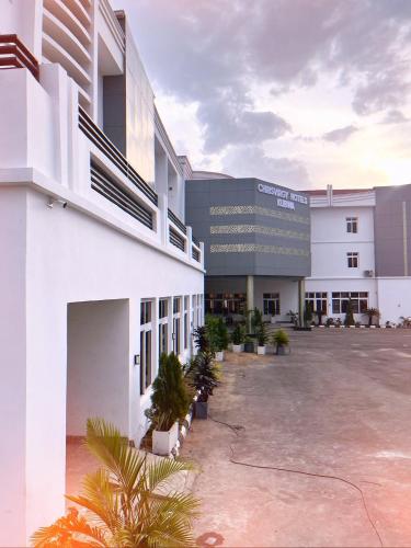 a large building with a parking lot in front of it at Chrisvirgy Hotels in Kubwa