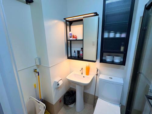 a bathroom with a sink and a mirror and a toilet at Penthouse Nook - Ananda square in Manila