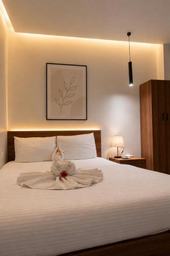 ein Schlafzimmer mit einem weißen Bett, auf dem ein Stofftier liegt in der Unterkunft فندق مونتو - Montu pYramids Hotel in Kairo