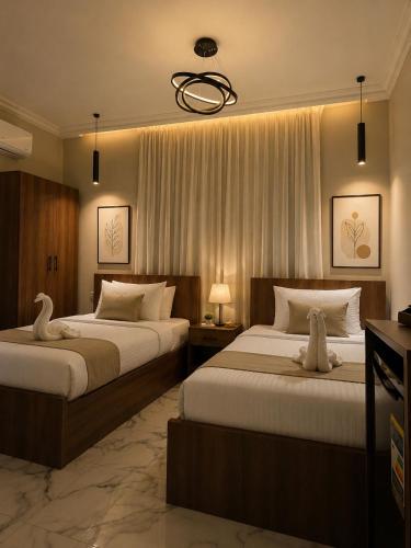 zwei Betten in einem Hotelzimmer mit zwei Schwänen darauf in der Unterkunft فندق مونتو - Montu pYramids Hotel in Kairo