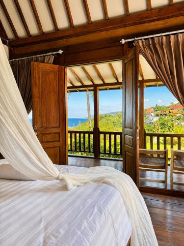 a bedroom with a bed with a view of the ocean at 5BR, Ocean View, Private Pool, Villas Roc-Azur in Sampalan