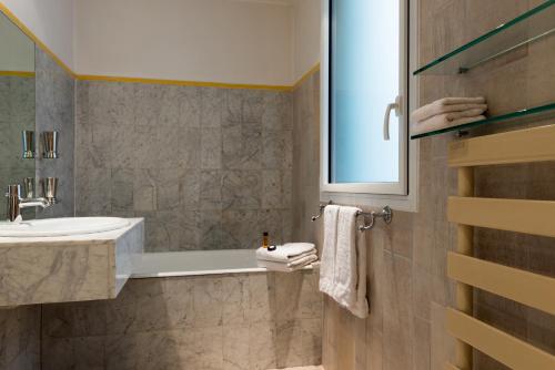 a bathroom with a sink and a bath tub at Hotel Danemark in Paris