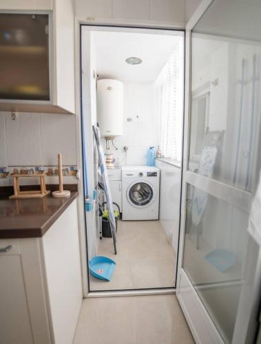 a kitchen with a washing machine and a microwave at House Atarfe LINING1 in Atarfe