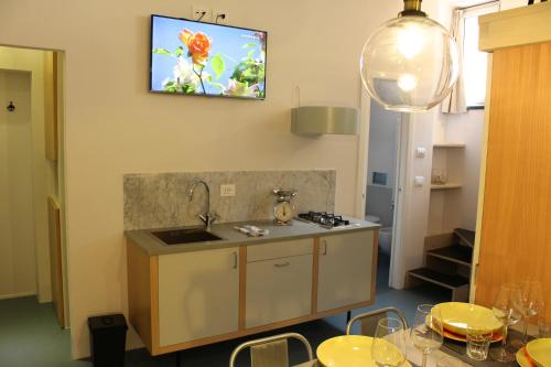 a kitchen with a sink and a tv on the wall at Appartamento della Baia in Sestri Levante