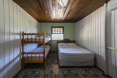 a room with two bunk beds and a window at Hospedaria Nativa in Praia do Rosa