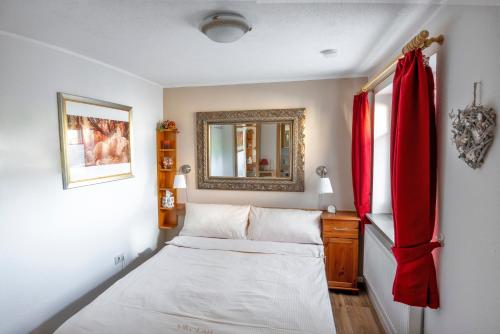 a small bedroom with a bed and a mirror at Ferienwohnungen Villa Lütt in Bleckede