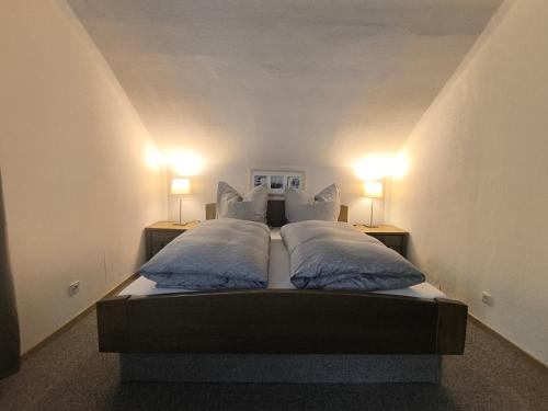 a bedroom with two beds with pillows and two lamps at Casa LuVilla in Braunlage