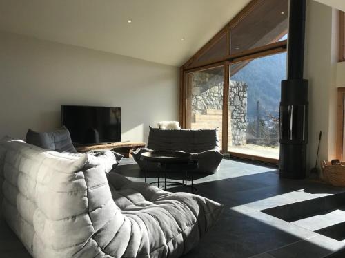 a living room with a white couch and a television at LE REFUGE DE LUCE in Saint-Gervais-les-Bains