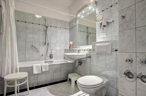 a bathroom with a toilet and a sink and a tub at Haus Seeblick Hotel Garni & Ferienwohnungen in Zinnowitz