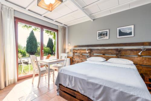 a bedroom with a bed and a table and a window at Ca'Luna Guest House in Mondovì