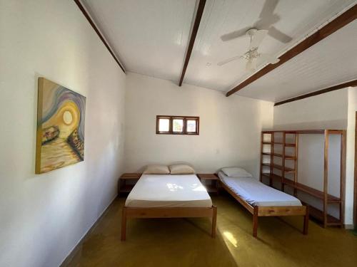 a room with two beds and a painting on the wall at Pousada Fanticelli in Nova Viçosa