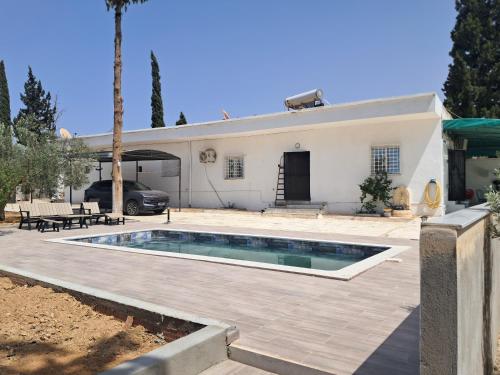 a villa with a swimming pool in front of a house at Domaine salma in Maherine