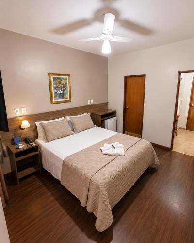 a bedroom with a large bed and a ceiling at CAMBRAIA HOTEL ARCOS in Arcos