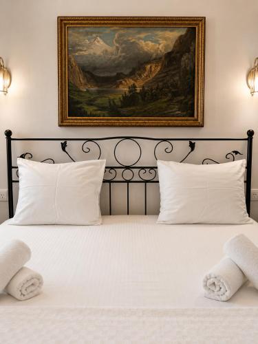 a bed with white pillows and a painting on the wall at Motto Polonezköy in Beykoz