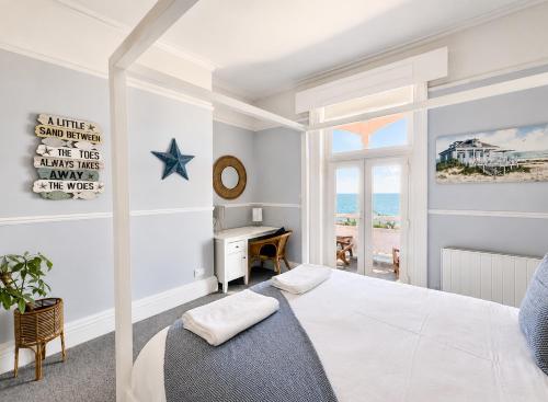 a white bedroom with a bed and a desk at A View Of The Bay- Close to Margate - Sleeps 3 in Westgate-on-Sea