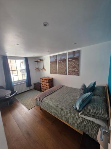 a bedroom with a large bed with blue pillows at The Salty Loft in Hastings