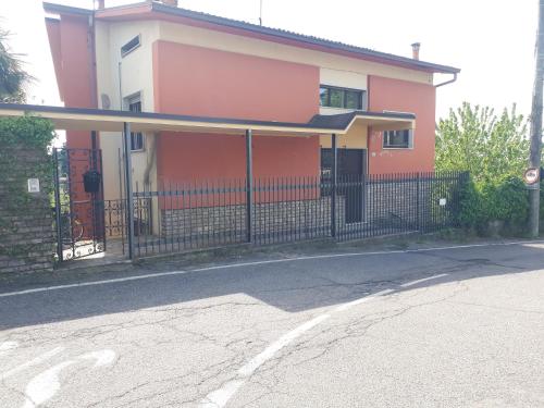 a pink house with a fence in front of it at La nuova casa di Giove in Palazzolo sullʼOglio