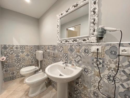 a bathroom with a sink and a toilet and a mirror at La Ginestra in Corleone