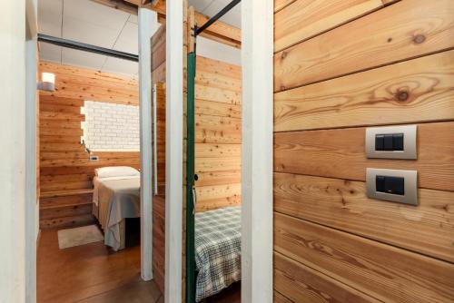 a room with a wooden wall with a door at Ca'Luna Guest House in Mondovì