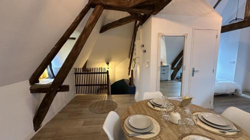 a dining room with a wooden table and chairs at L'ombrelle in Chablis
