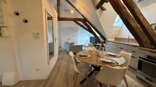 a kitchen and dining room with a wooden table and chairs at L'ombrelle in Chablis