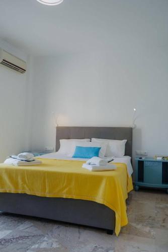 a bedroom with a large bed with a yellow blanket at Vickys Apartment Diakopto in Diakopto