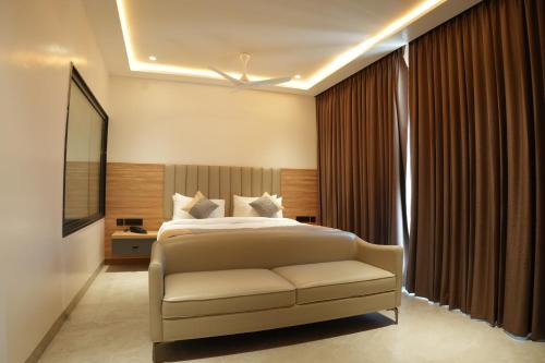 a bedroom with a bed and a chair in a room at Hotel Kalyani Landmark in Elūru