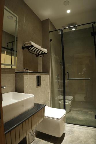 a bathroom with a white sink and a shower at Hotel Kalyani Landmark in Elūru