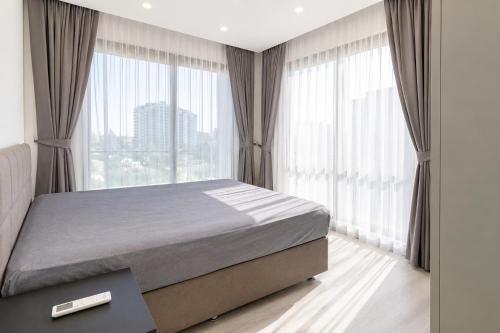 a bedroom with a large bed and large windows at Blue life Long beach in Iskele