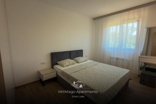a bedroom with a bed and a window at Miti Apartment with Marina View & Spa Access in Veliko Gradište
