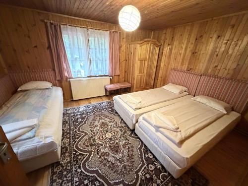 two beds in a room with wooden walls at Persey Villa Borovets in Borovets