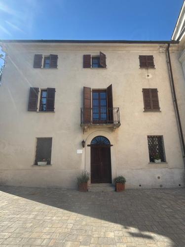 a building with windows and a door and a balcony at Guest House Villa Castello in Nucetto