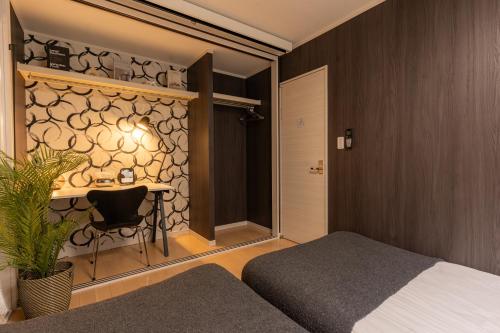 a bedroom with a bed and a table with a chair at The Ichikawa House in Ichikawa