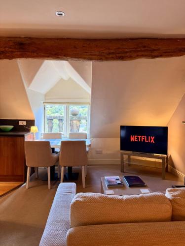 a living room with a couch and a tv at Bagshaw Hall in Bakewell