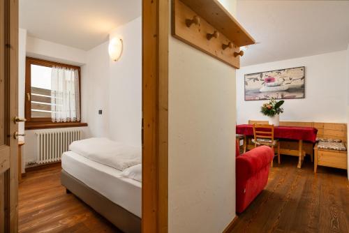 a bedroom with a bed and a dining room with a table at Residence Miramonti in Daiano