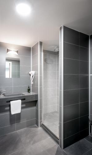 a bathroom with a shower with a glass door at Hotel Library Amsterdam in Amsterdam