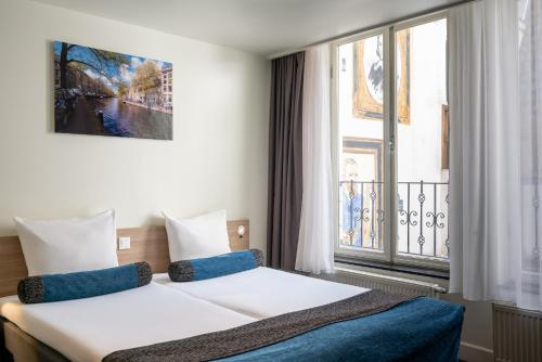 a hotel room with a bed and a window at Hotel Library Amsterdam in Amsterdam